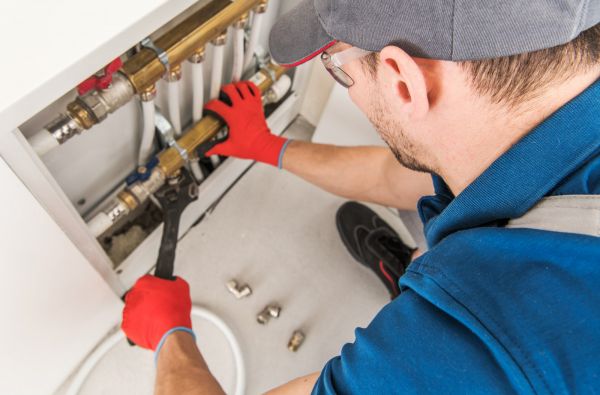 A 24-hour Canberra plumber fixing the hot water system connections