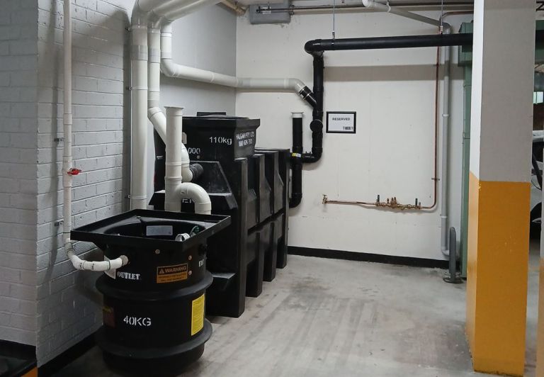 a commercial setup showcasing a black grease trap installed by level plumbing commercial division