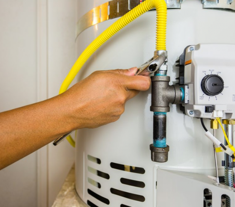 a Canberra plumber tightening a nut on a hot water heater