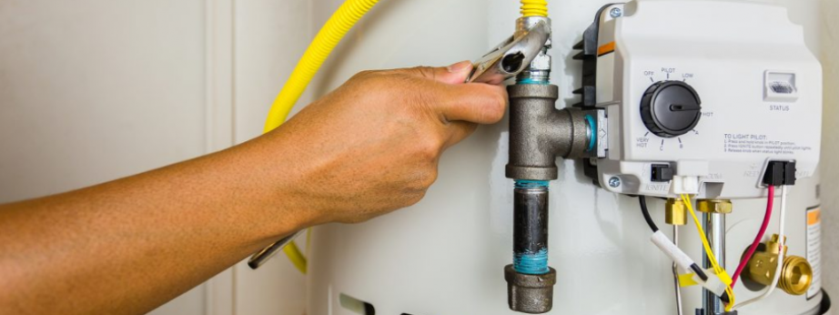a Canberra plumber tightening a nut on a hot water heater