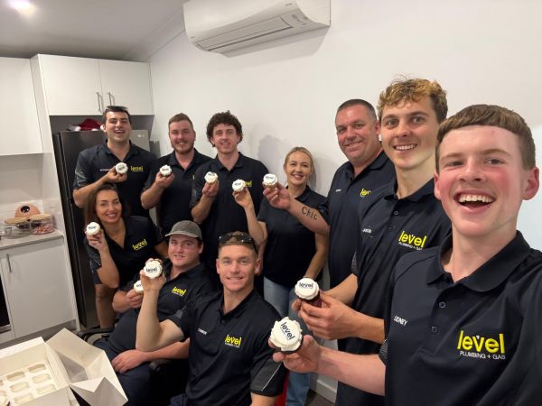 Level Plumbing and Gas Newcastle Central team celebrating the new brand launch with Level branded cupcakes.
