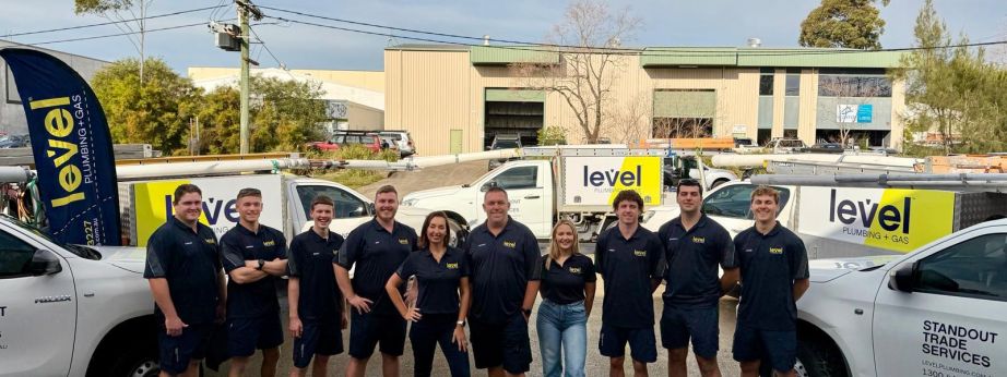 Level Plumbing and Gas Newcastle Central team standing in front of newly branded Level vehicles.