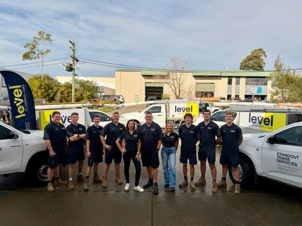 Level Plumbing and Gas Newcastle Central team standing in front of newly branded Level vehicles.
