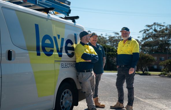 Level Electrical Newcastle Central team standing beside branded service vehicle, ready to deliver commercial electrical projects across Newcastle and Port Stephens.