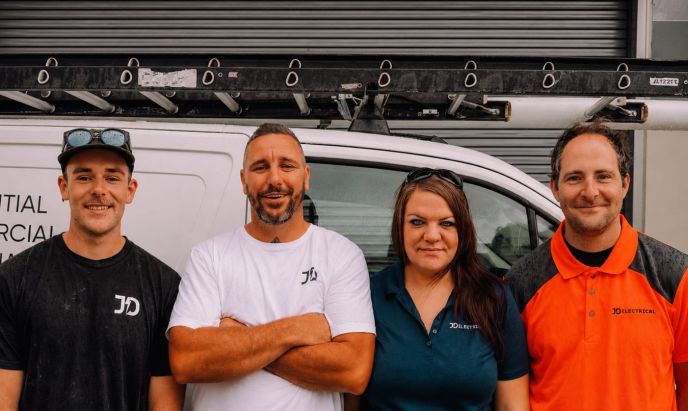 Four members of the Level Electrical Lake Macquarie team standing in front of their electrical service vehicle.