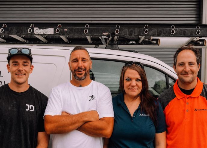 Four members of the Level Electrical Lake Macquarie team standing in front of their electrical service vehicle.