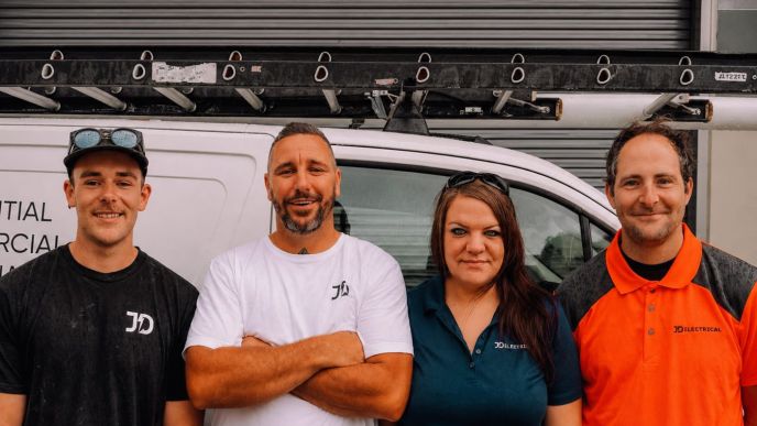 Four members of the Level Electrical Lake Macquarie team standing in front of their electrical service vehicle.