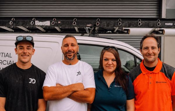 Four members of the Level Electrical Lake Macquarie team standing in front of their electrical service vehicle.
