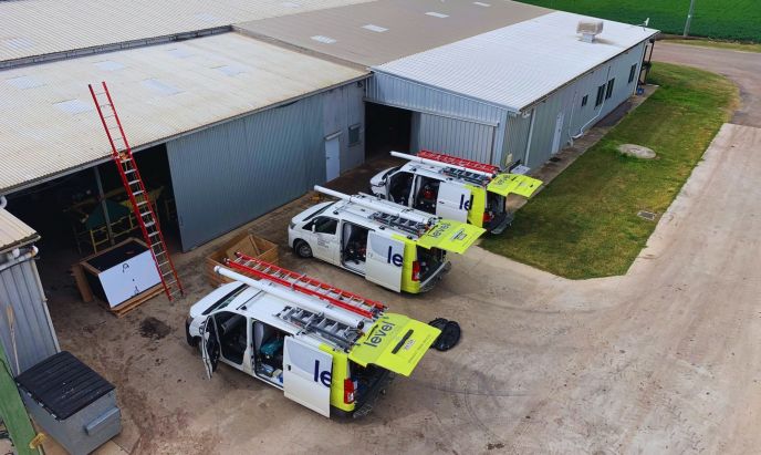 Level Electrical service vehicles parked at a commercial warehouse site in Australia during electrical works