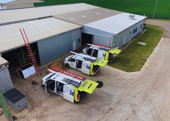 Level Electrical service vehicles parked at a commercial warehouse site in Australia during electrical works