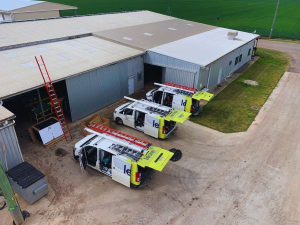 Level Electrical service vehicles parked at a commercial warehouse site in Australia during electrical works