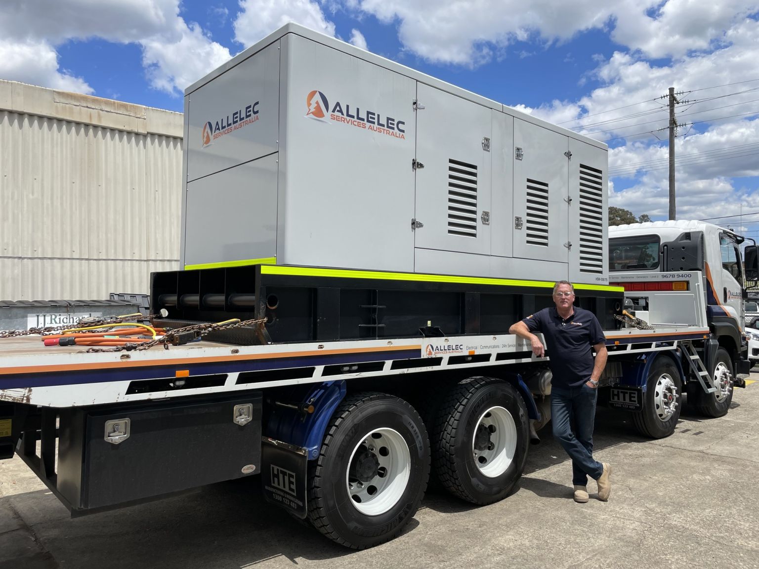 Allelec Services Australia generator being transported on a truck for a commercial electrical project in Sydney.