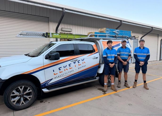 Three members of the Leketek team beside their branded electrical work vehicle in Mackay.