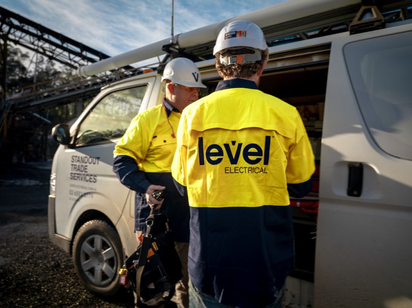 Level electrical technicians preparing tools beside a service vehicle on a commercial site in Australia