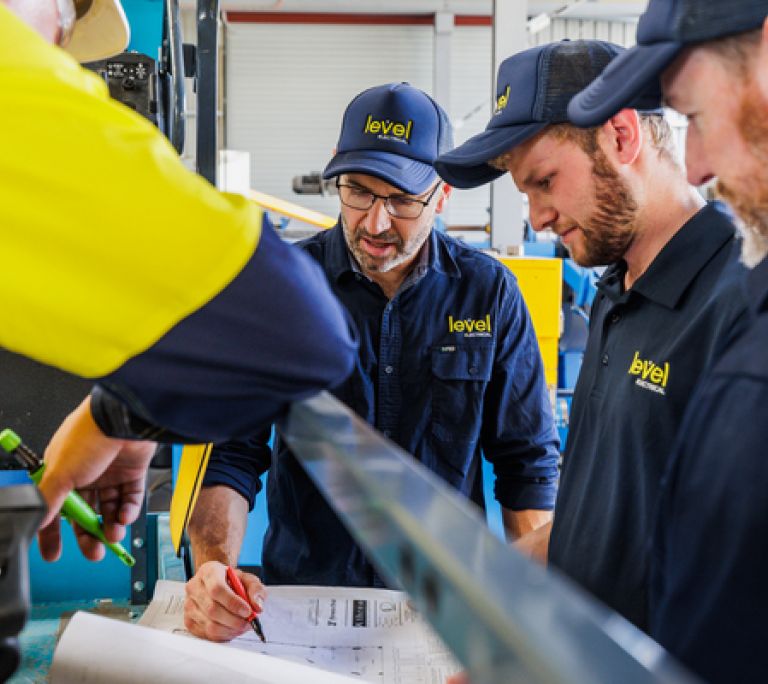 Level Electrical technicians reviewing electrical plans during a commercial installation project in Australia