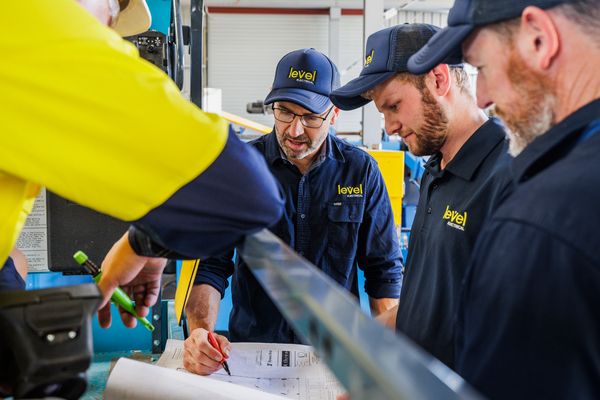 Level Electrical technicians reviewing electrical plans during a commercial installation project in Australia