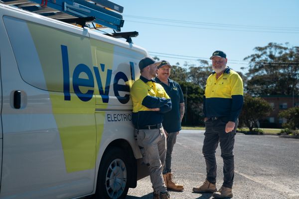 Level Electrical Newcastle Central team standing beside branded service vehicle, ready to deliver commercial electrical projects across Newcastle and Port Stephens.
