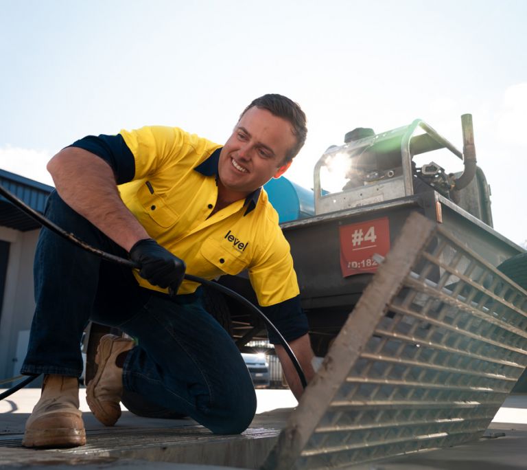 Level plumber clearing a blocked drain during plumbing maintenance work in Australia
