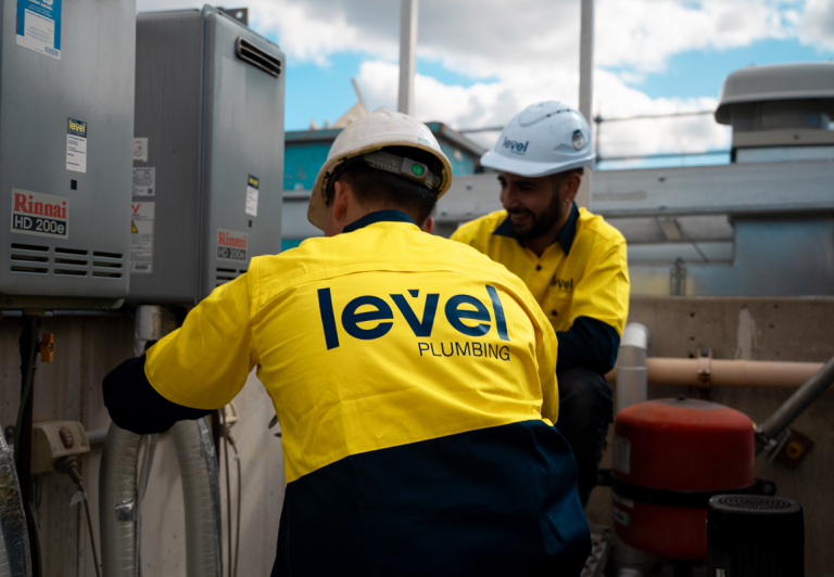 Level plumbing technicians installing and servicing hot water system equipment in Australia