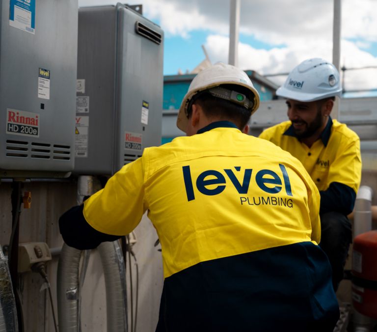 Level plumbing technicians installing and servicing hot water system equipment in Australia
