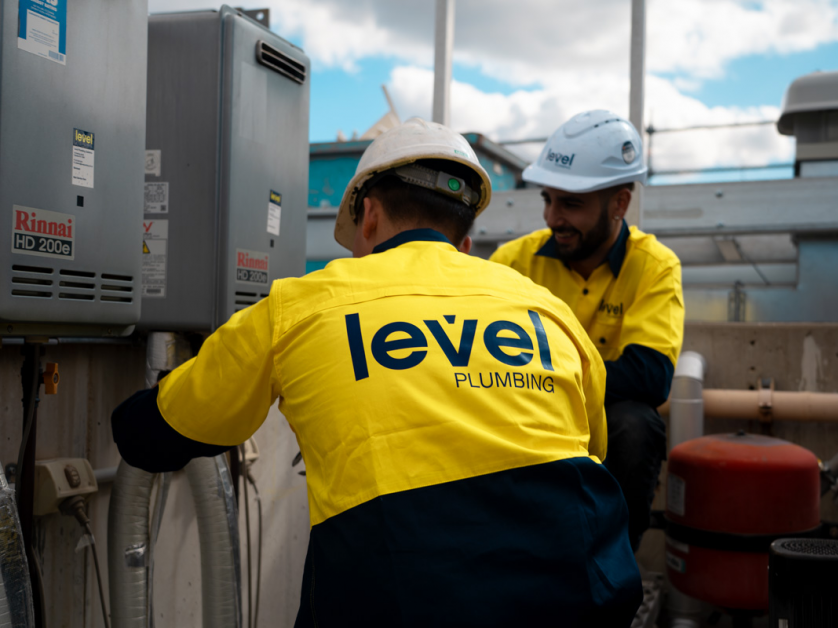 Level plumbing technicians installing and servicing hot water system equipment in Australia