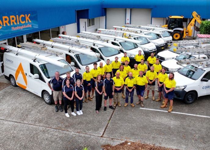 Carrick Plumbing & Roofing team with service vehicles at their Port Macquarie headquarters, part of Level Group Australia