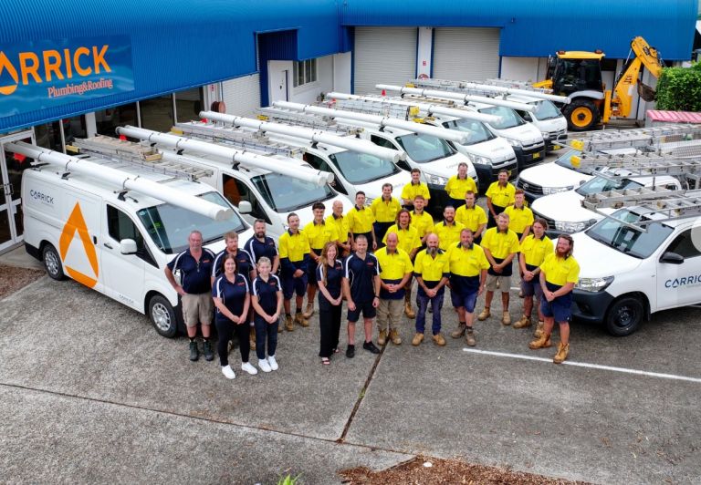 Carrick Plumbing & Roofing team with service vehicles at their Port Macquarie headquarters, part of Level Group Australia