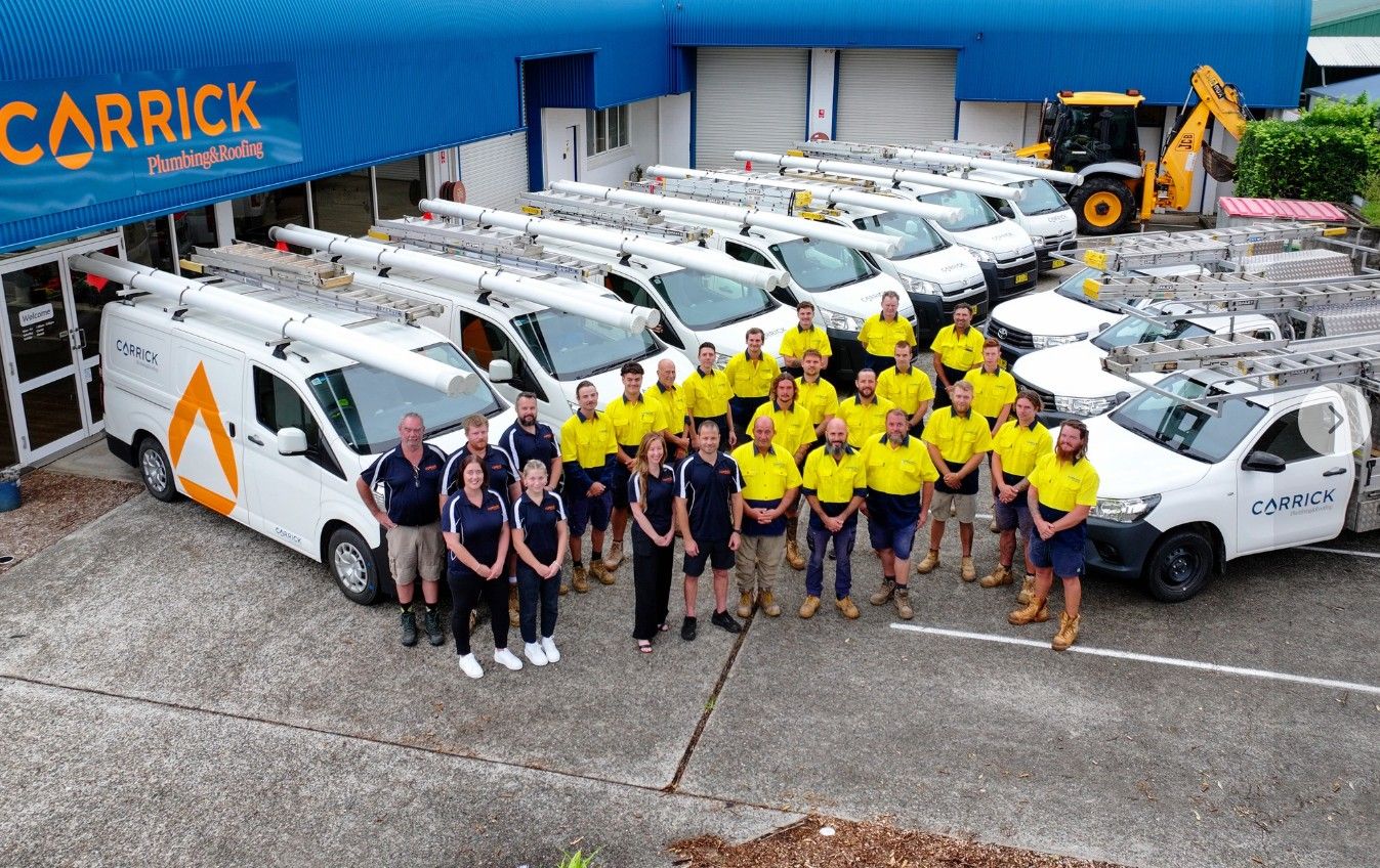 Carrick Plumbing & Roofing team with service vehicles at their Port Macquarie headquarters, part of Level Group Australia