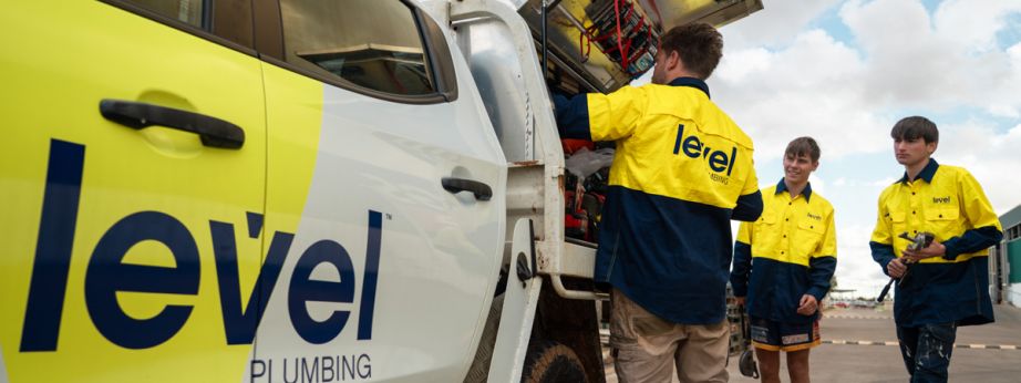 Level plumbing technicians accessing equipment from a service truck on site in Australia