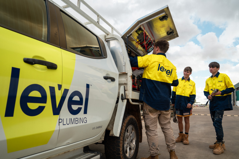 Level plumbing technicians accessing equipment from a service truck on site in Australia