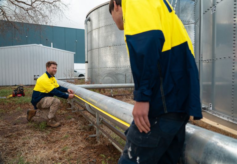 Level plumber measuring pipe during inspection prior to pipe relining work