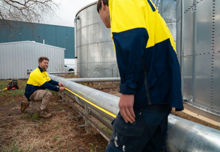 Level plumber measuring pipe during inspection prior to pipe relining work