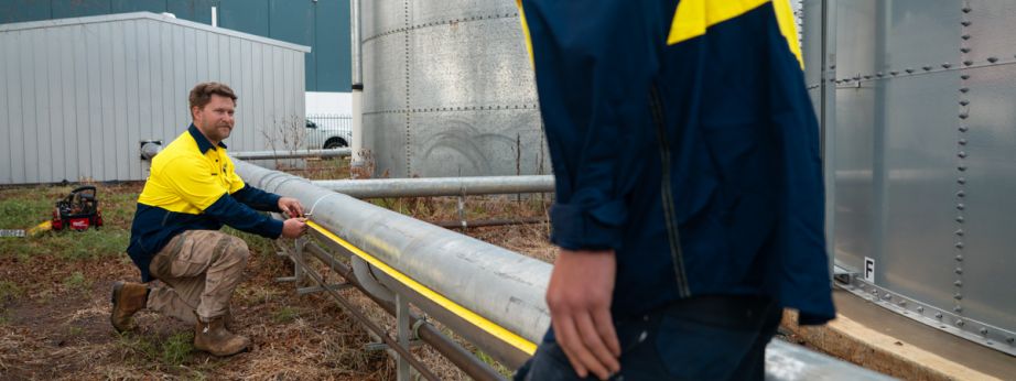 Level plumber measuring pipe during inspection prior to pipe relining work