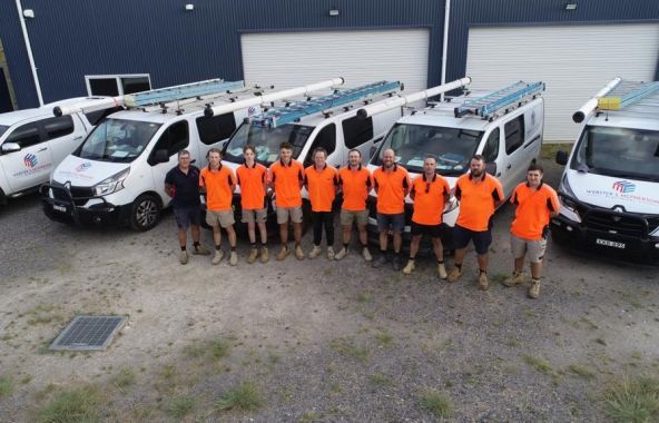 Webster & McPherson Electrical team standing in front of branded service vehicles before rebranding to Level Electrical & Data Goulburn.