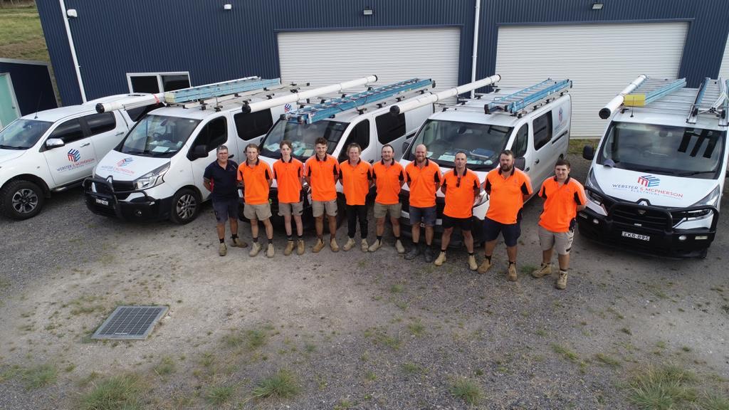 Webster & McPherson Electrical team standing in front of branded service vehicles before rebranding to Level Electrical & Data Goulburn.