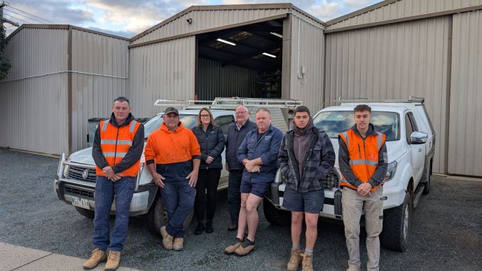Richard Grogan and the Level Plumbing Shepparton team standing in front of their vehicles at the Shepparton workshop.