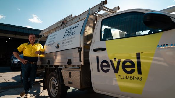 Level Plumbing Canberra technician standing beside fully equipped emergency response vehicle ready to assist customers