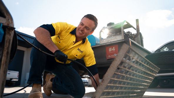 Level Plumbing Canberra technician using a high-pressure jetter to clear a blocked drain as part of general plumbing maintenance services