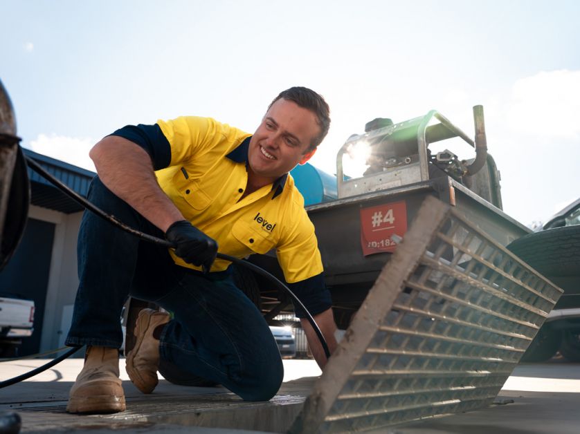 Level Plumbing Canberra technician using a high-pressure jetter to clear a blocked drain as part of general plumbing maintenance services