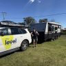 Calvin Hudson, owner of Level Electrical West Gosford, standing in front of branded service vehicle and trailer showcasing Level alliance success